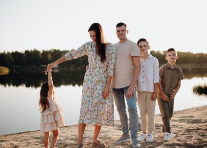 A family of five enjoys a serene lakeside vacation at sunset, capturing precious moments together.
